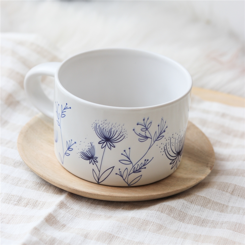 Weißer Becher mit Blumendekoration